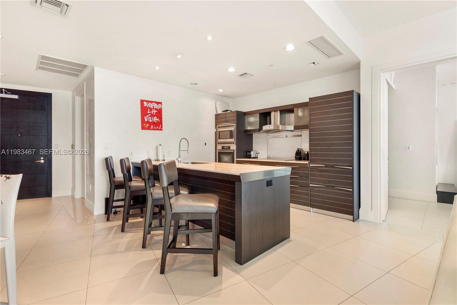 200 Biscayne Blvd Way, Unit 4907 Miami, FL 33131 - Photo 3 of 18 a open kitchen with stainless steel appliances granite countertop a table and chairs