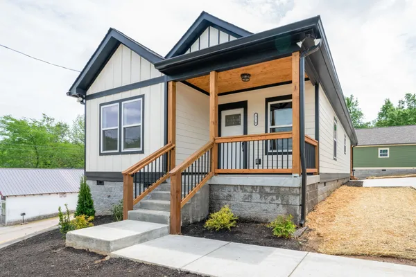 a front view of a house with a yard and potted plants