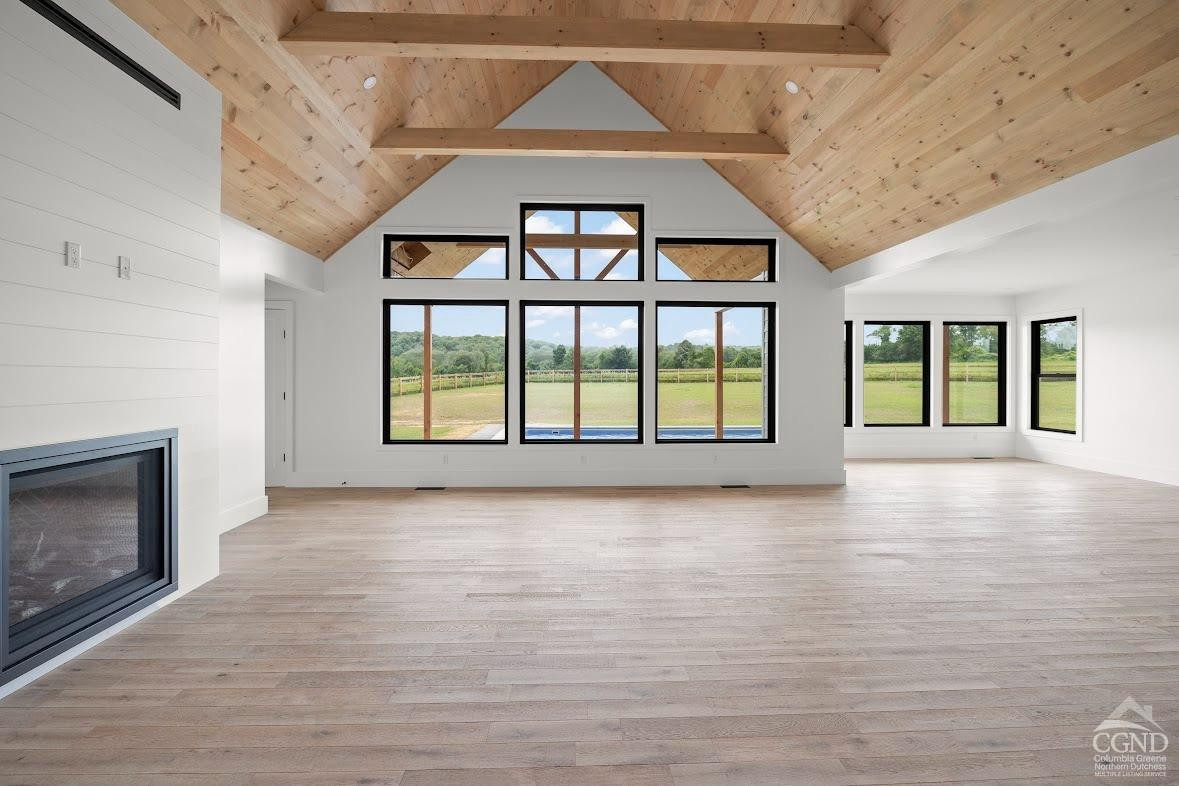 49 Snyder Pond Road Copake, NY 12516 - Photo 11 of 25 an empty room with wooden floor fireplace and windows