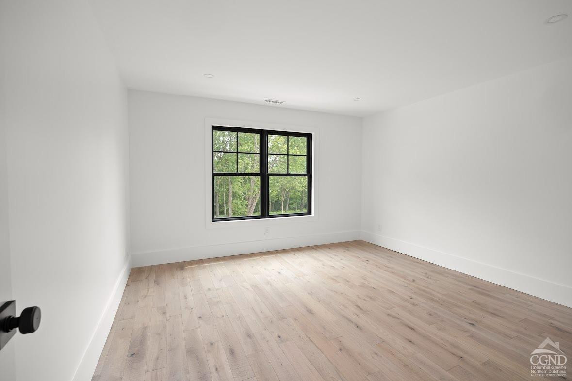 49 Snyder Pond Road Copake, NY 12516 - Photo 15 of 25 an empty room with wooden floor and windows