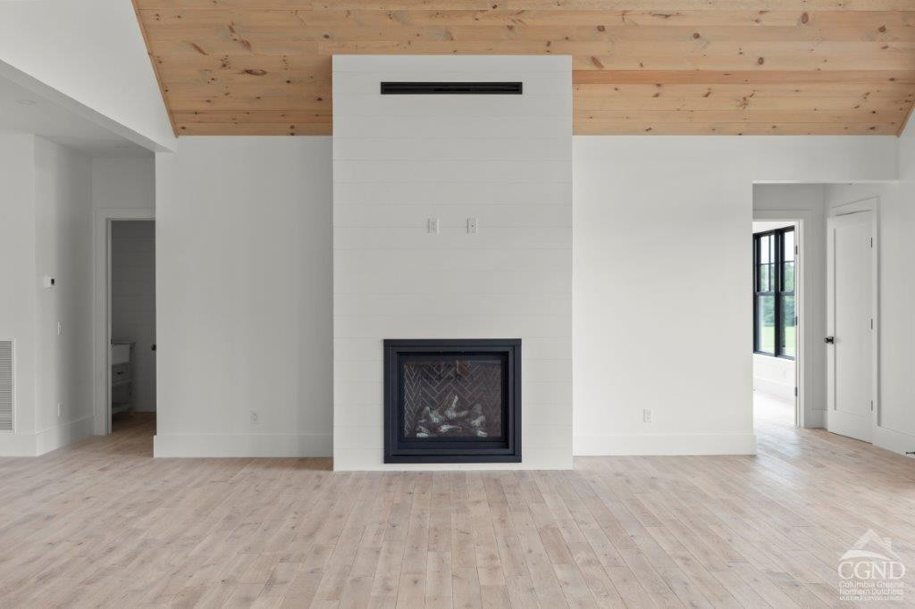 49 Snyder Pond Road Copake, NY 12516 - Photo 20 of 25 an empty room with a fireplace and wooden floor