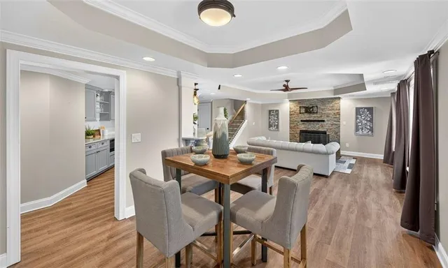 a living room with couches and a refrigerator with wooden floor