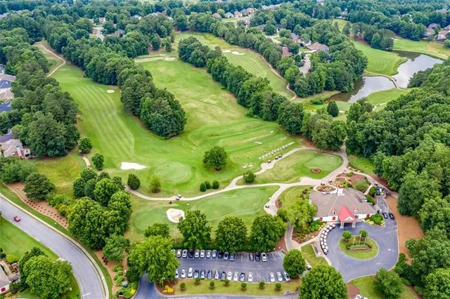 an aerial view of a tennis ground with a house and a yard