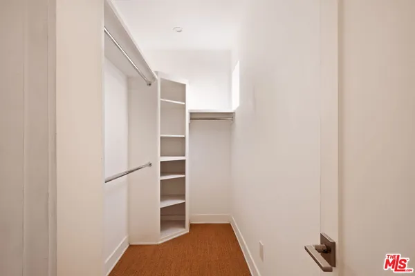 a view of walk in closet with empty racks