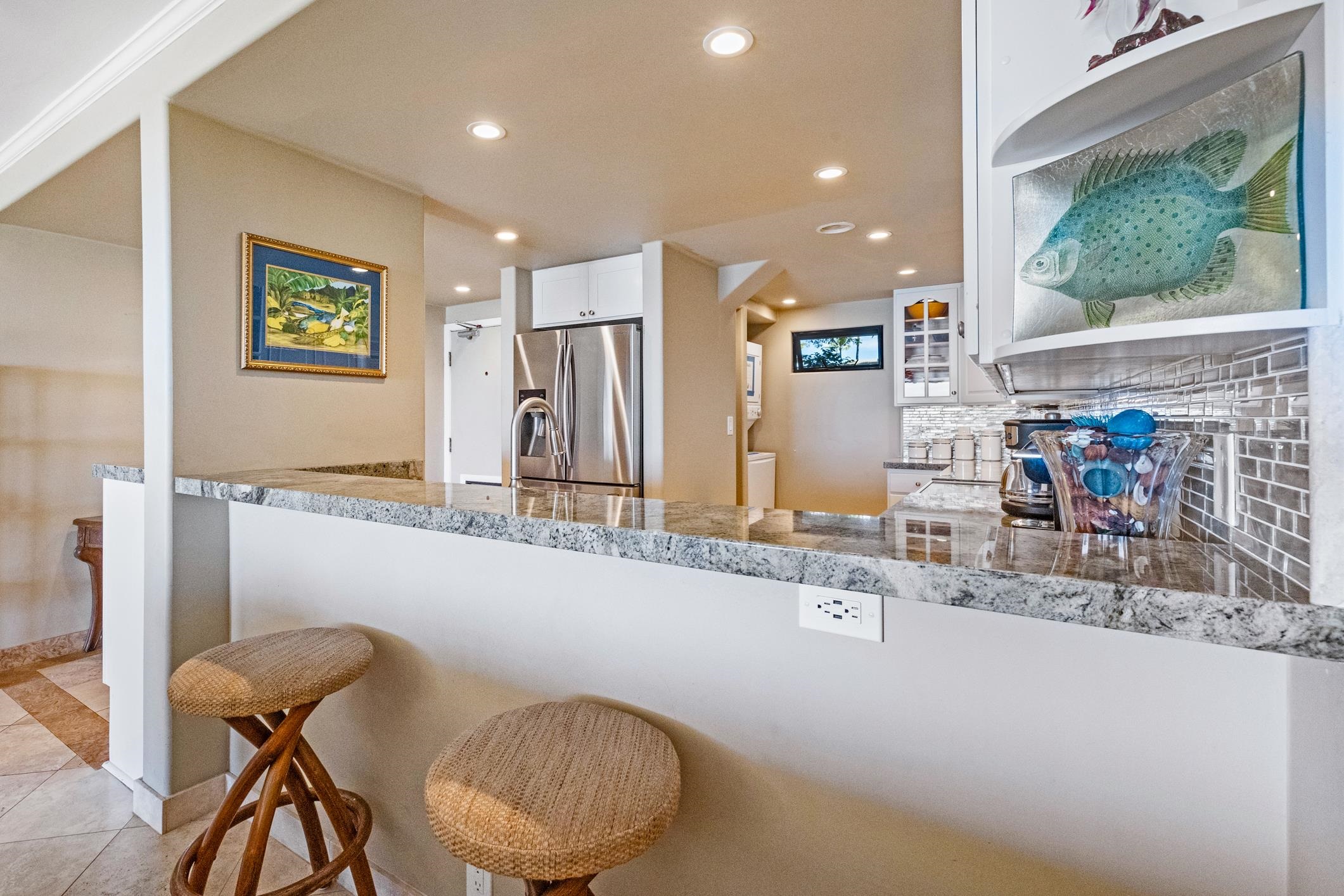 4401 Lower Honoapiilani Road, Unit A103 Lahaina, HI 96761 - Photo 12 of 45 a kitchen with stainless steel appliances granite countertop a sink and a refrigerator