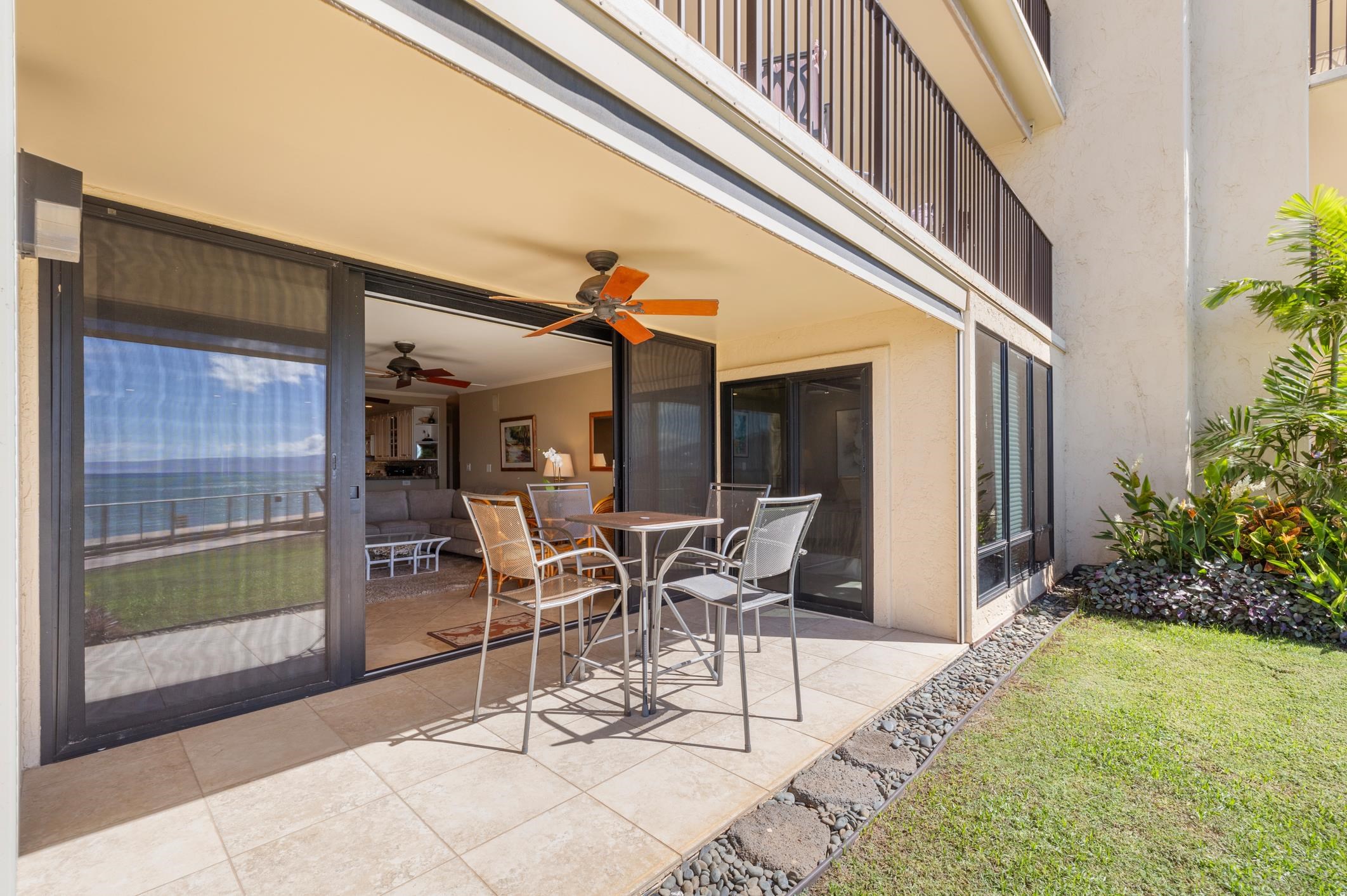4401 Lower Honoapiilani Road, Unit A103 Lahaina, HI 96761 - Photo 25 of 45 a patio with table and chairs and potted plants