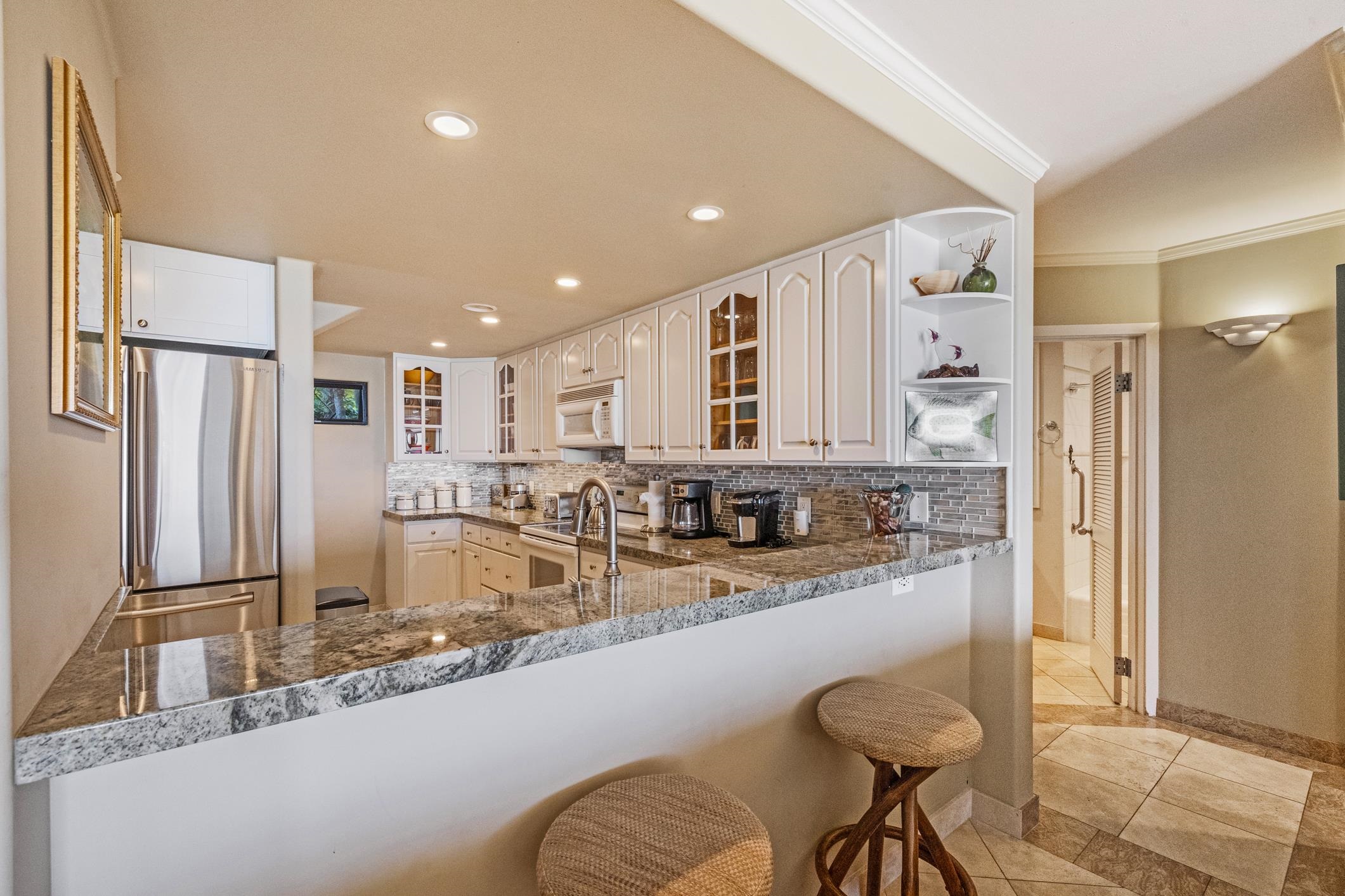 4401 Lower Honoapiilani Road, Unit A103 Lahaina, HI 96761 - Photo 30 of 45 a kitchen with stainless steel appliances granite countertop a refrigerator and a sink