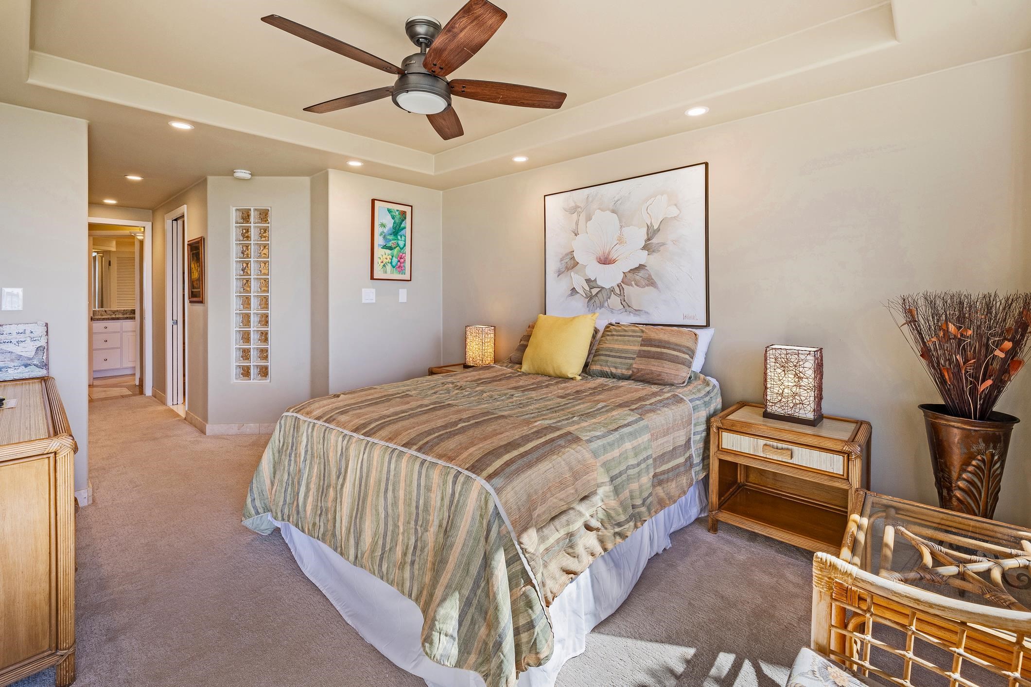 4401 Lower Honoapiilani Road, Unit A103 Lahaina, HI 96761 - Photo 38 of 45 a bedroom with a bed and a painting on the wall