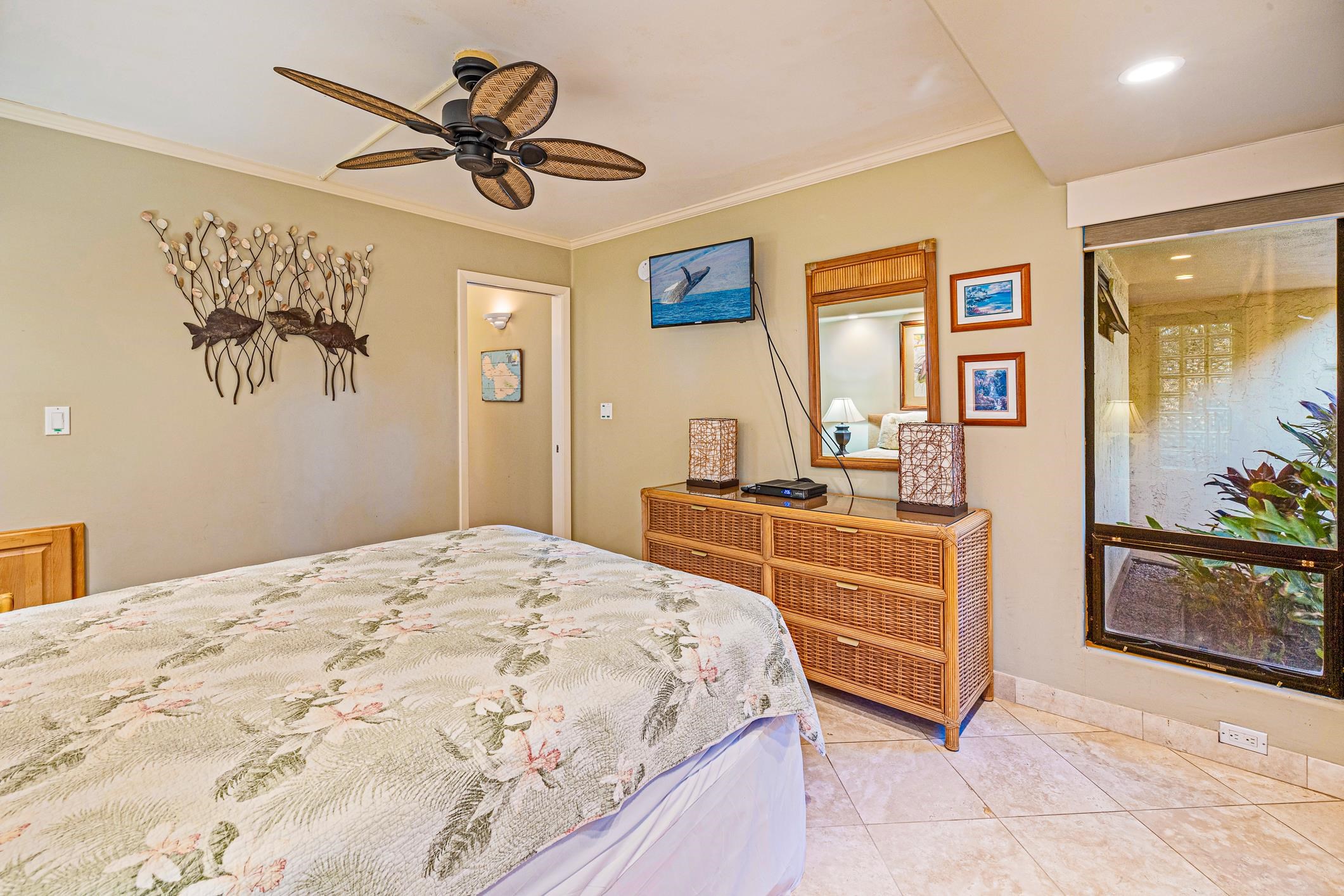 4401 Lower Honoapiilani Road, Unit A103 Lahaina, HI 96761 - Photo 43 of 45 a bedroom with a bed and a chandelier