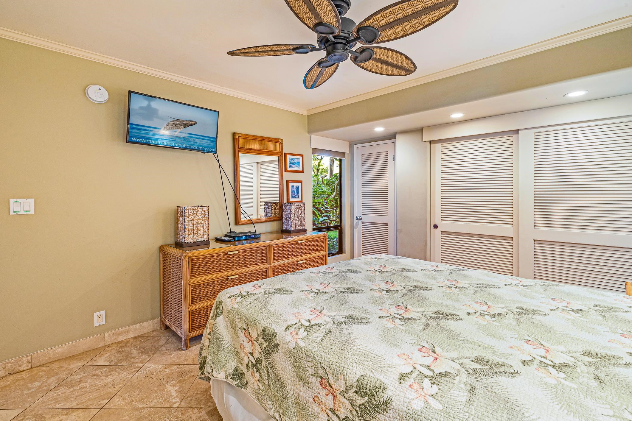 4401 Lower Honoapiilani Road, Unit A103 Lahaina, HI 96761 - Photo 44 of 45 a bedroom with a bed and a chandelier