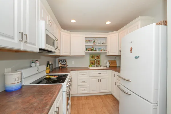 a kitchen with white cabinets and white appliances