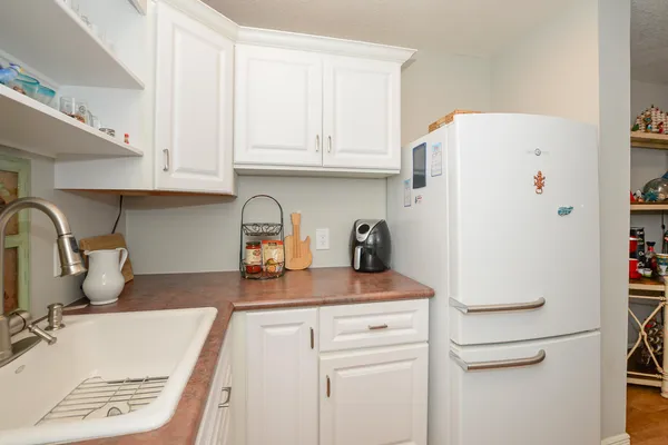 a kitchen with refrigerator and cabinets