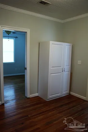 a view of empty room with wooden floor