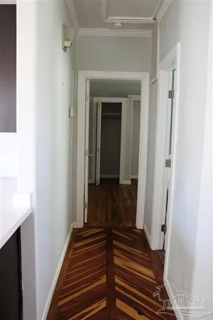 a view of a hallway with wooden floor and staircase