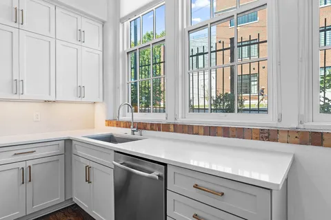 a kitchen with stainless steel appliances granite countertop a stove and white cabinets