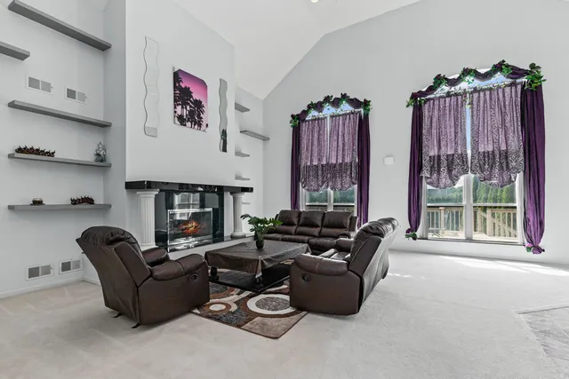 a living room with furniture a fireplace and a large window
