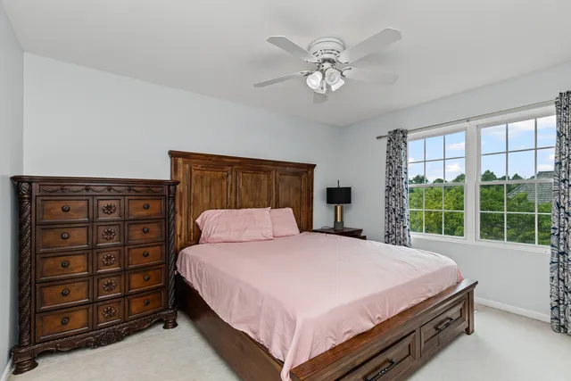 a bedroom with a bed a dresser next to a window