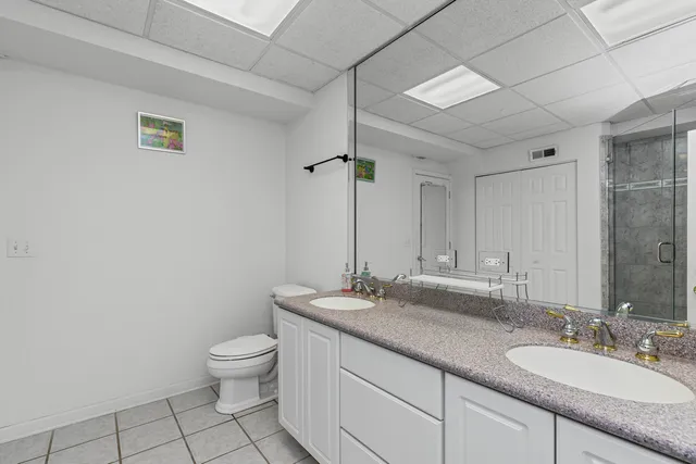 a bathroom with a granite countertop sink a toilet and a mirror