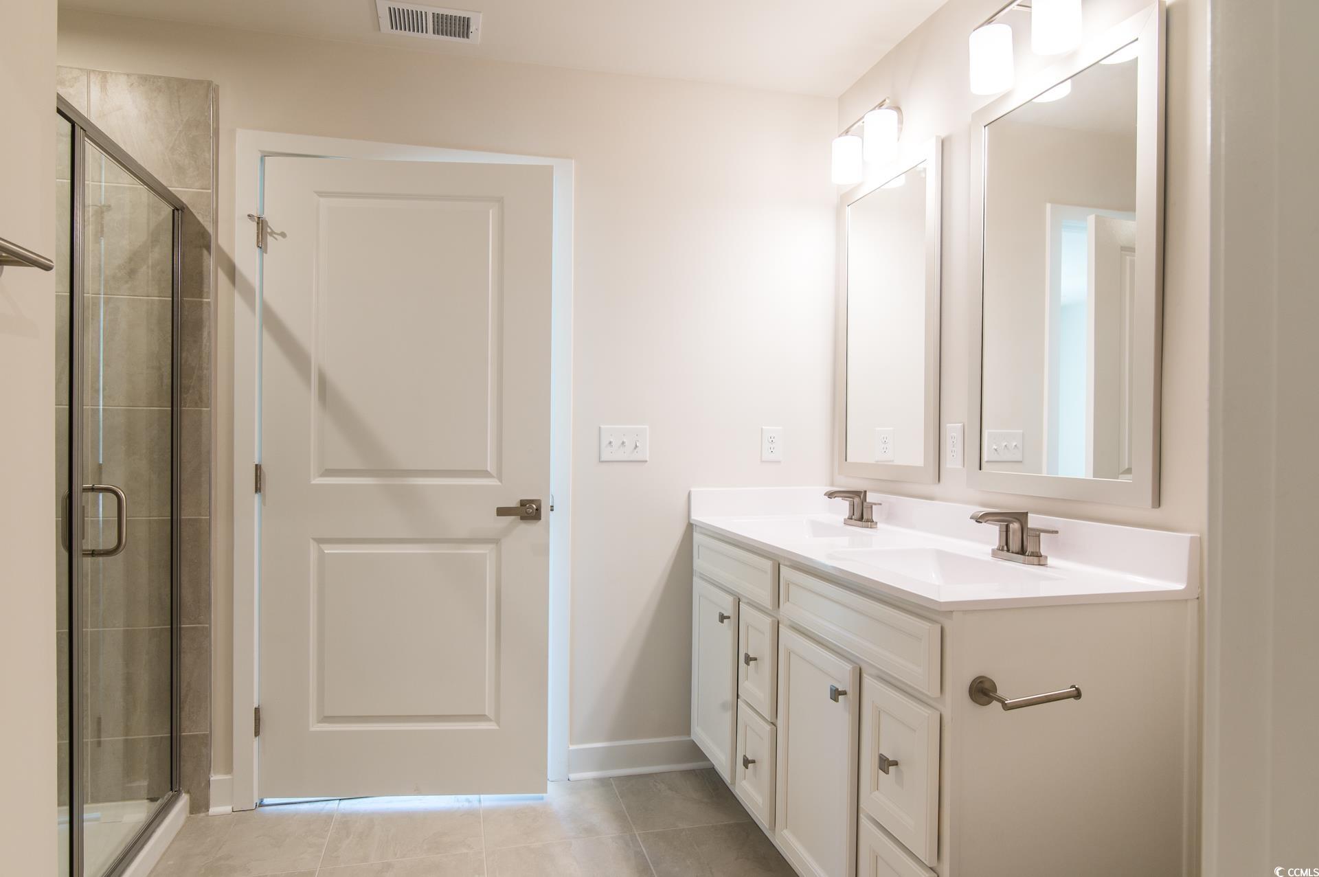 2382 Elowen Lane Longs, SC 29568 - Photo 14 of 36 Full bathroom with double vanity, a stall shower, and light tile patterned floors