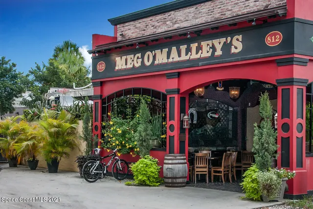 a view of a big house with large trees and windows