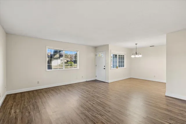 a view of a chandelier in an empty room with wooden floor and a chandelier