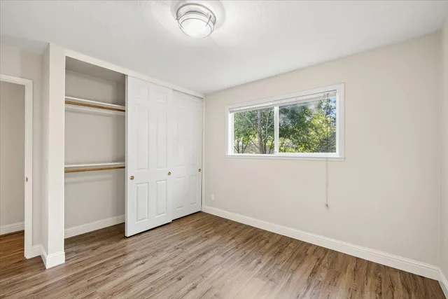 an empty room with wooden floor and window