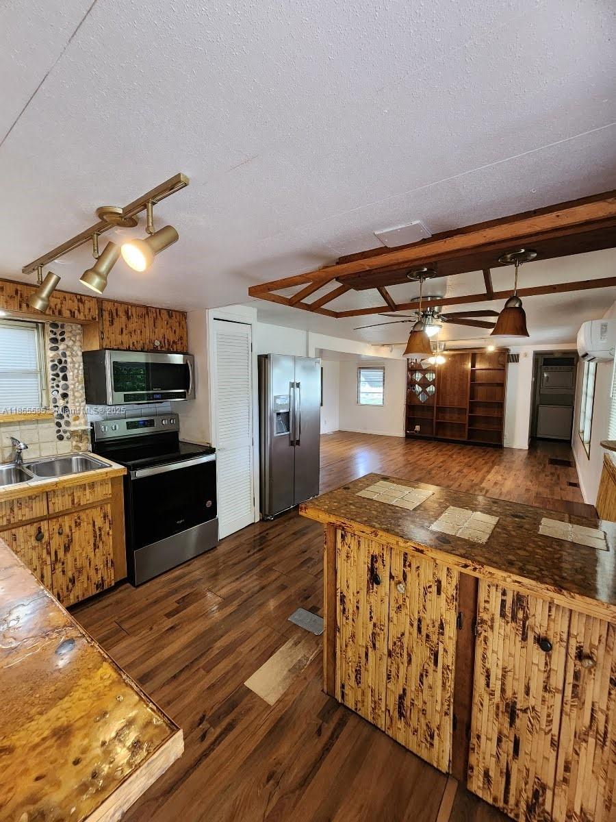1590 Southwest 65th Terrace, Unit H Boca Raton, FL 33428 - Photo 2 of 17 a kitchen with stainless steel appliances wooden cabinets and a stove top oven