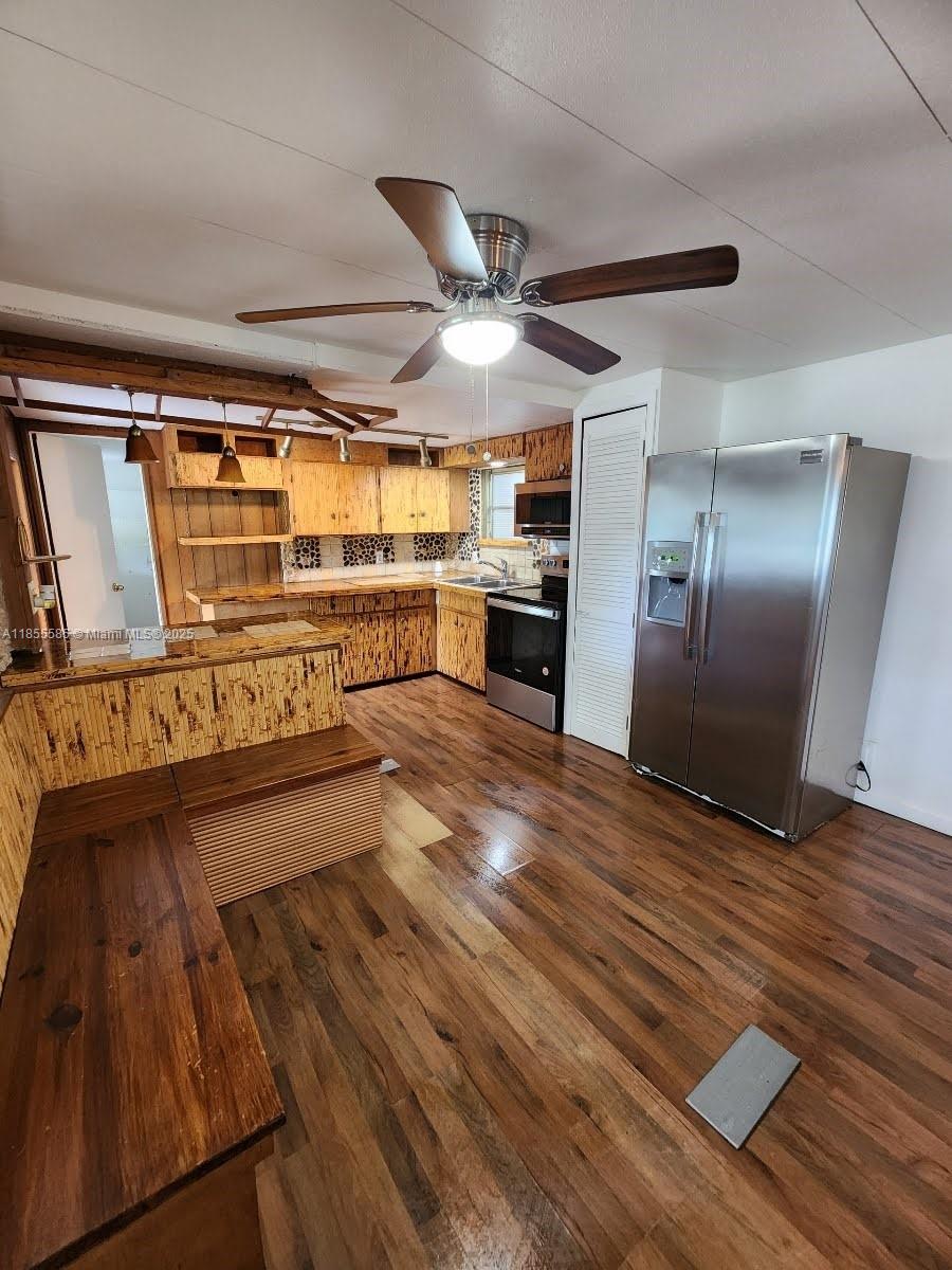 1590 Southwest 65th Terrace, Unit H Boca Raton, FL 33428 - Photo 3 of 17 a view of an empty room with wooden floor and a kitchen