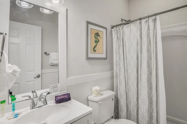 a bathroom with a sink a toilet and shower curtain