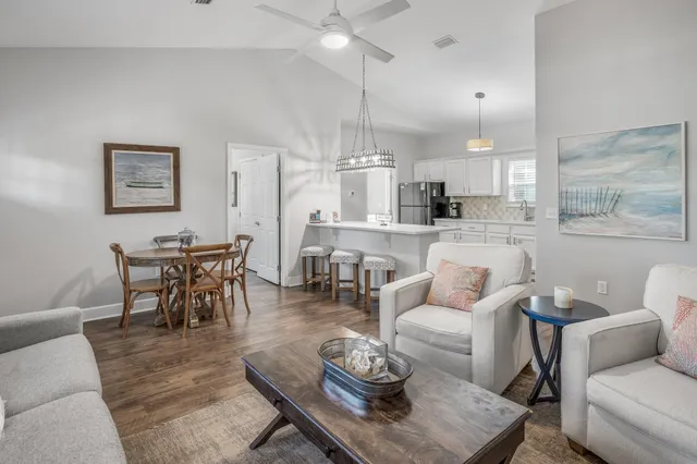 a living room with furniture kitchen view and a chandelier