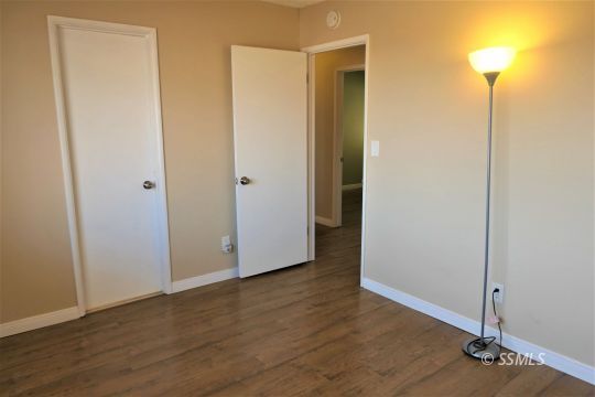 214 South Fire Opal Street Ridgecrest, CA 93555 - Photo 18 of 29 a view of an empty room with wooden floor and a closet
