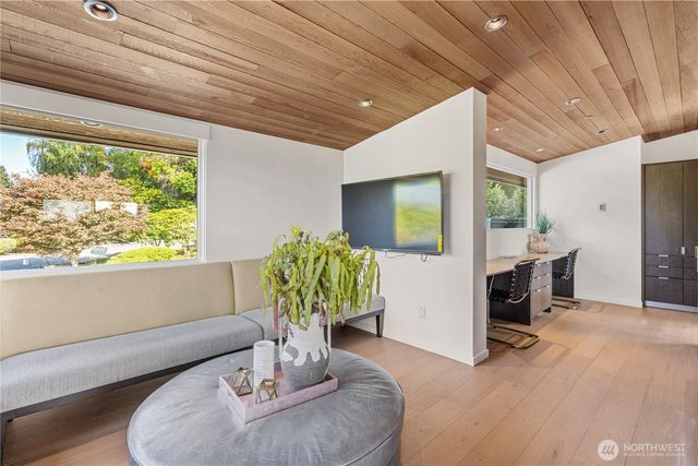 a dining room with furniture potted plants and wooden floor