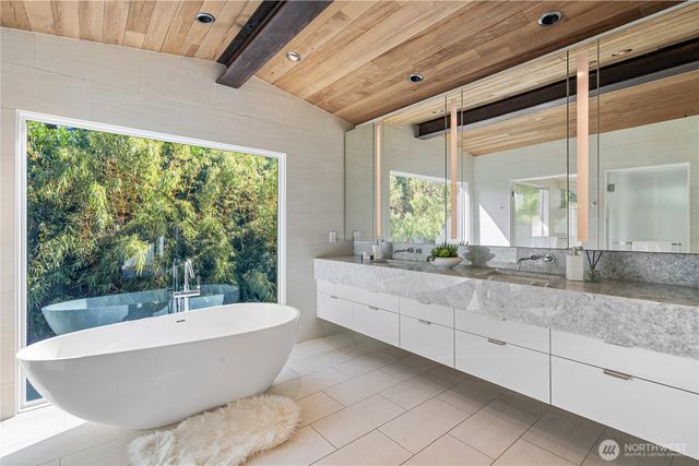 a bathroom with a granite countertop sink and bathtub