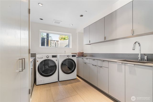 a utility room with sink dryer and washer