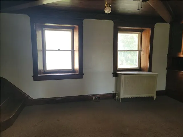 en empty room with windows and ceiling fan