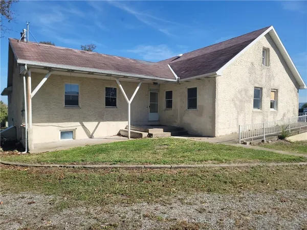 a view of a yard in front of a house with large windows