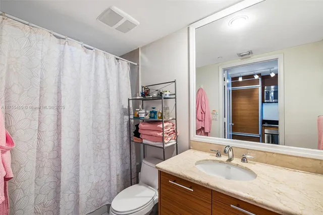 a bathroom with a sink vanity mirror and toilet