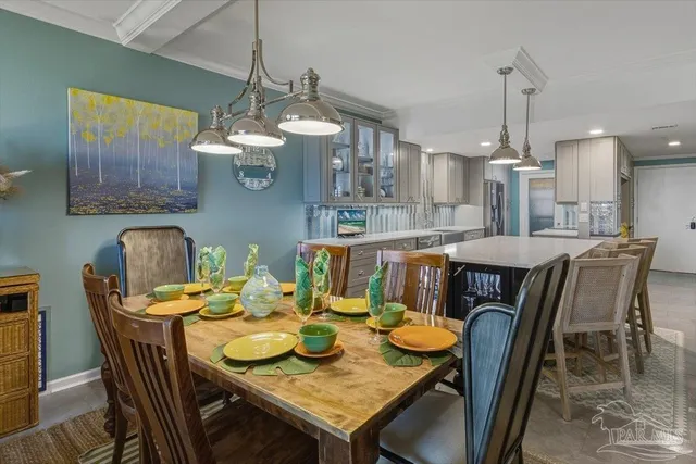 a dining room with furniture a chandelier a kitchen view and a chandelier