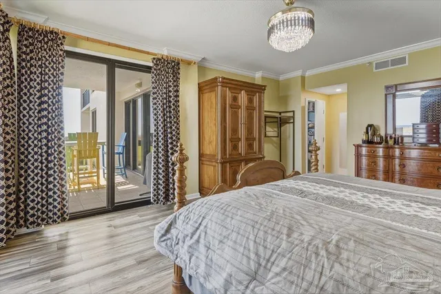 a bedroom with a large bed and a chandelier