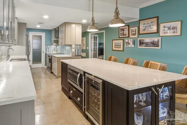 a kitchen with stainless steel appliances granite countertop a kitchen island a stove a refrigerator a oven a sink a dining table and chairs