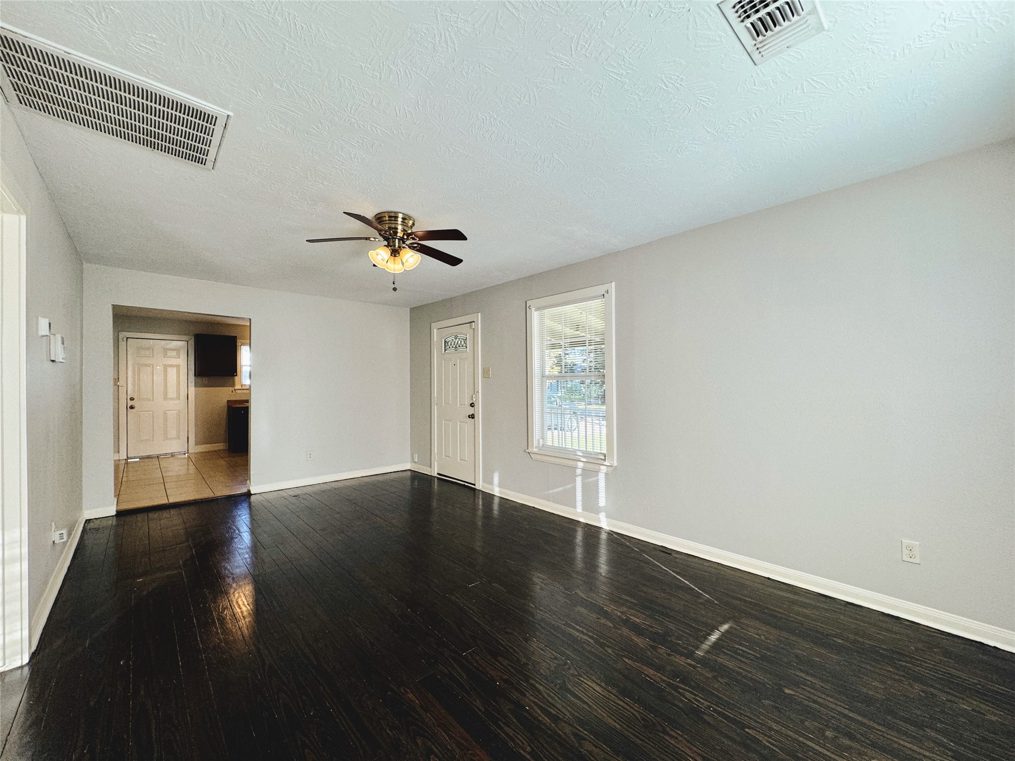 6714 Dillon Street Houston, TX 77061 - Photo 6 of 20 a view of an empty room with wooden floor and a window