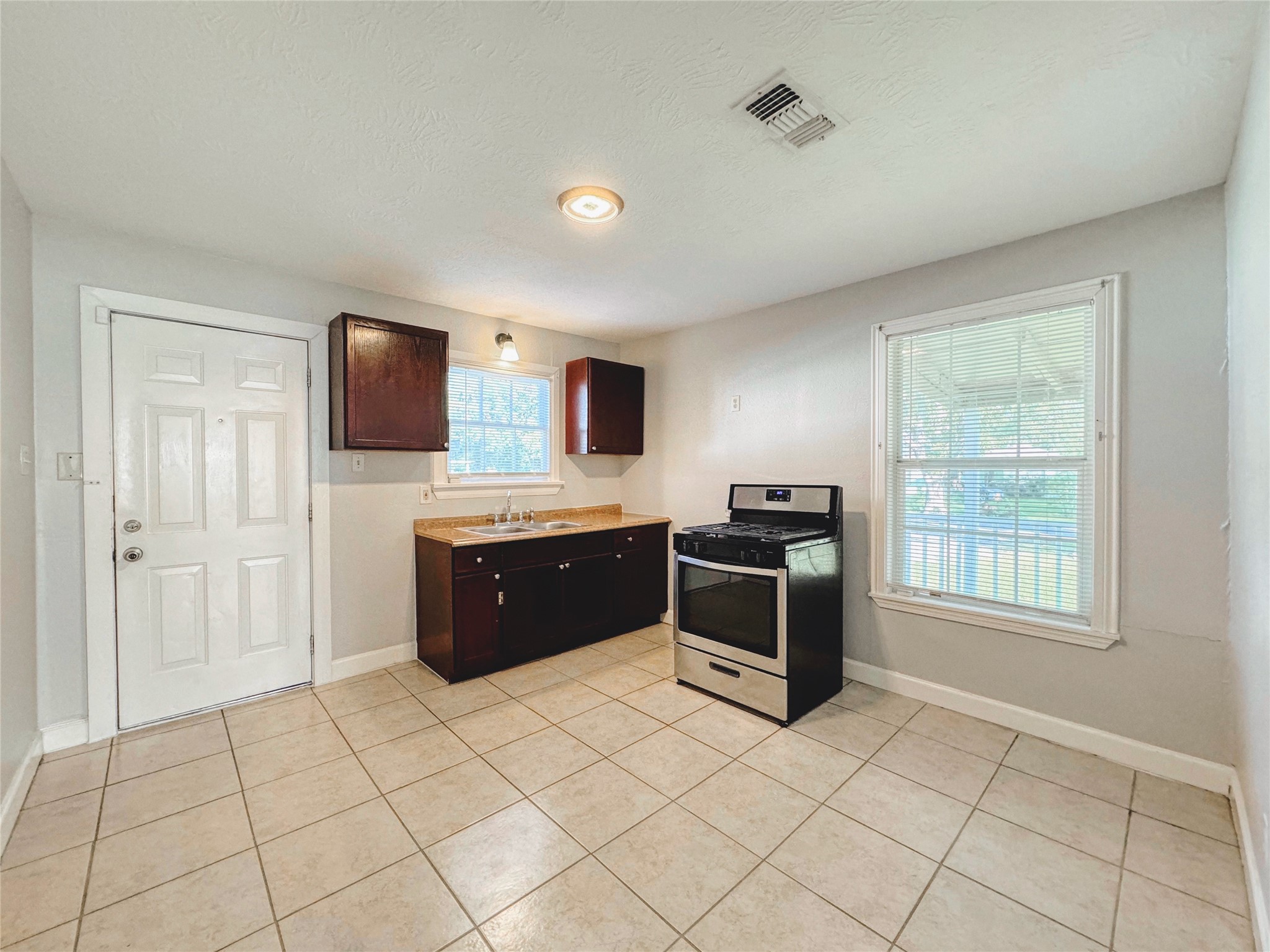 6714 Dillon Street Houston, TX 77061 - Photo 7 of 20 a large kitchen with a stove a sink and a microwave