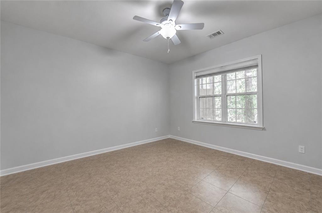 3977 Howell Park Road Duluth, GA 30096 - Photo 4 of 25 an empty room with a window and a fan