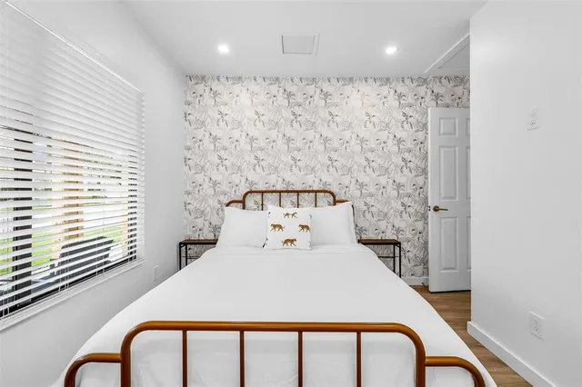 a bedroom with a bed and a large window