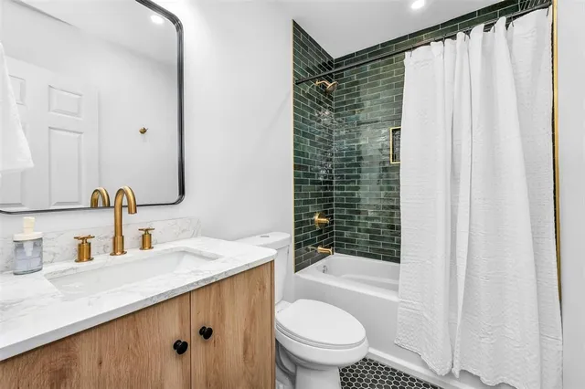 a bathroom with a granite countertop sink toilet and shower