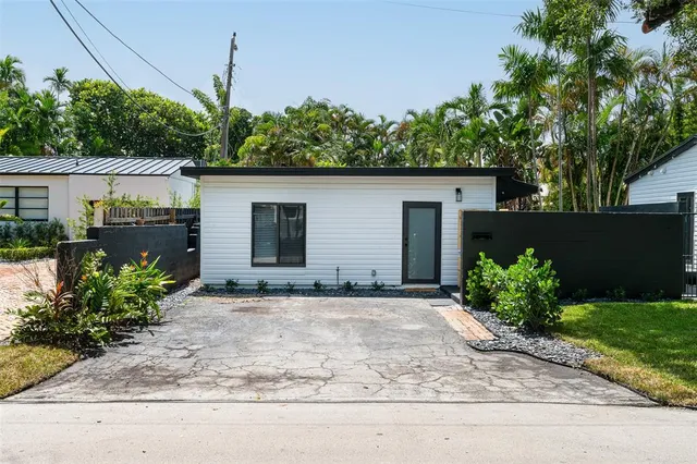 a front view of a house with a yard and a garden