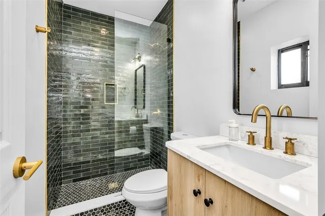 a bathroom with a granite countertop sink toilet and shower