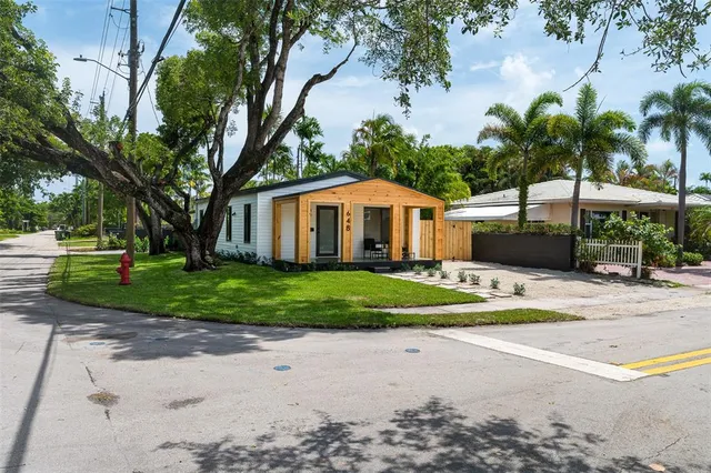 a front view of a house with a yard and potted plants