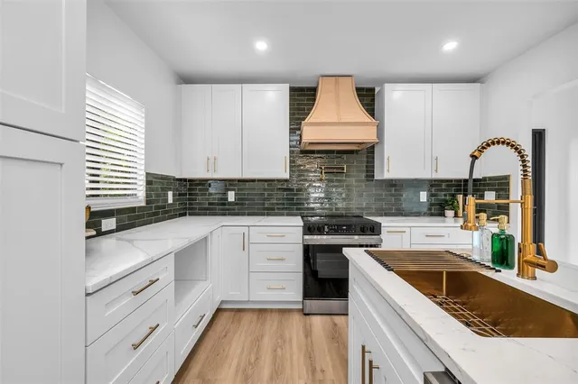 a kitchen with white cabinets appliances and a sink