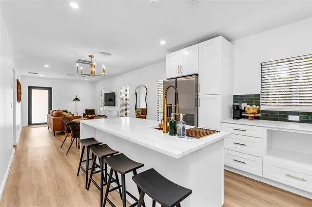 a kitchen with white cabinets and stainless steel appliances